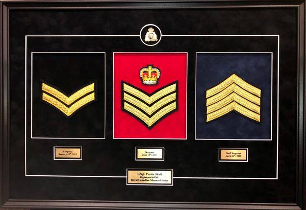 Framed display of Canadian military rank insignias for Corporal, Sergeant, and Staff Sergeant.