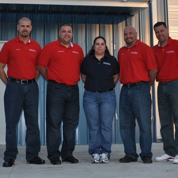 Four men a woman in front of their business