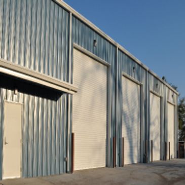 Blue building with 4 large, white bay doors