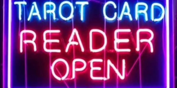 Neon sign reading 'Tarot Card Reader Open' in bright colors.