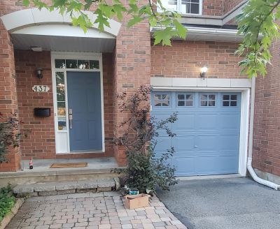 Blue door and garage on a brick house.
