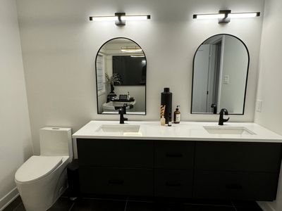 Modern bathroom with double sinks and black fixtures.