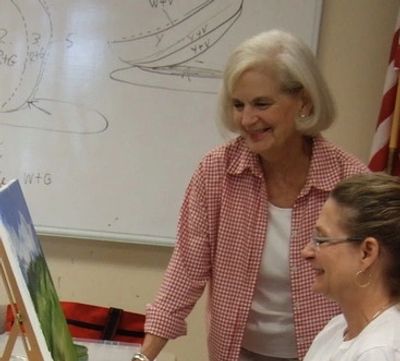 Picture of an artist helping students.