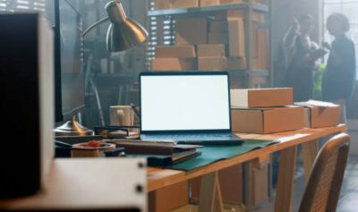 Workspace with laptop and cardboard boxes.
