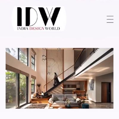 Modern double-height living room with staircase and large windows.