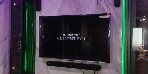 Modern TV setup with green ambient lighting and a marble backdrop.