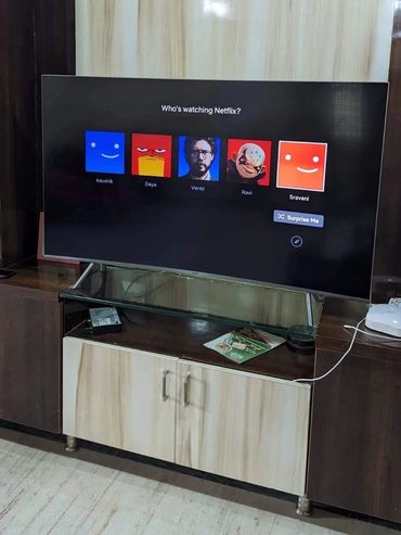 TV screen showing Netflix user profiles with different avatars and names.