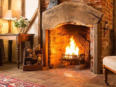 A brick fireplace with fire burning