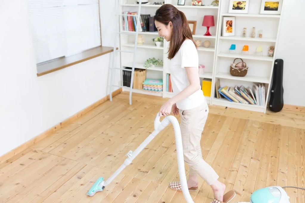 Girl vacuuming a floor.