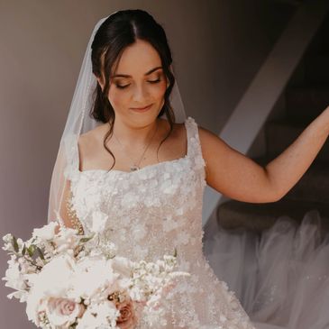 Bride in a floral wedding dress holding a bouquet.