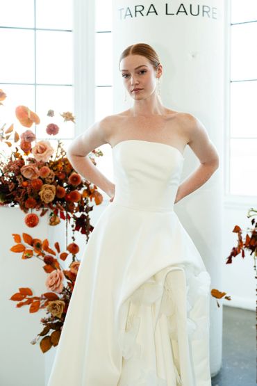 Elegant bride in a strapless white wedding gown with floral details.