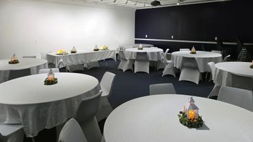 Event room with round tables and lantern centerpieces.