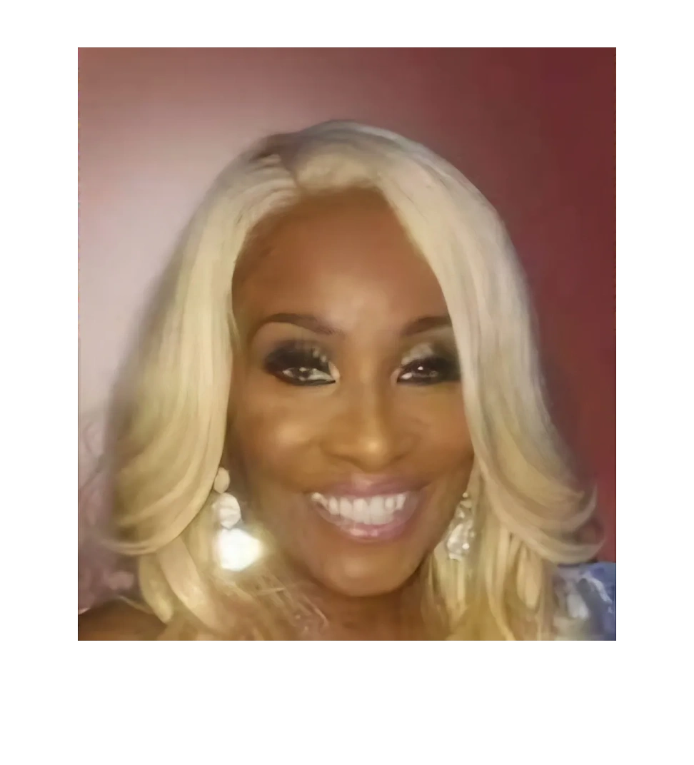 Smiling woman with blonde hair and glamorous makeup against a pink background.