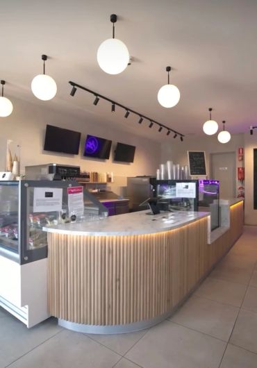 Modern cafe counter with a sleek design and warm lighting.