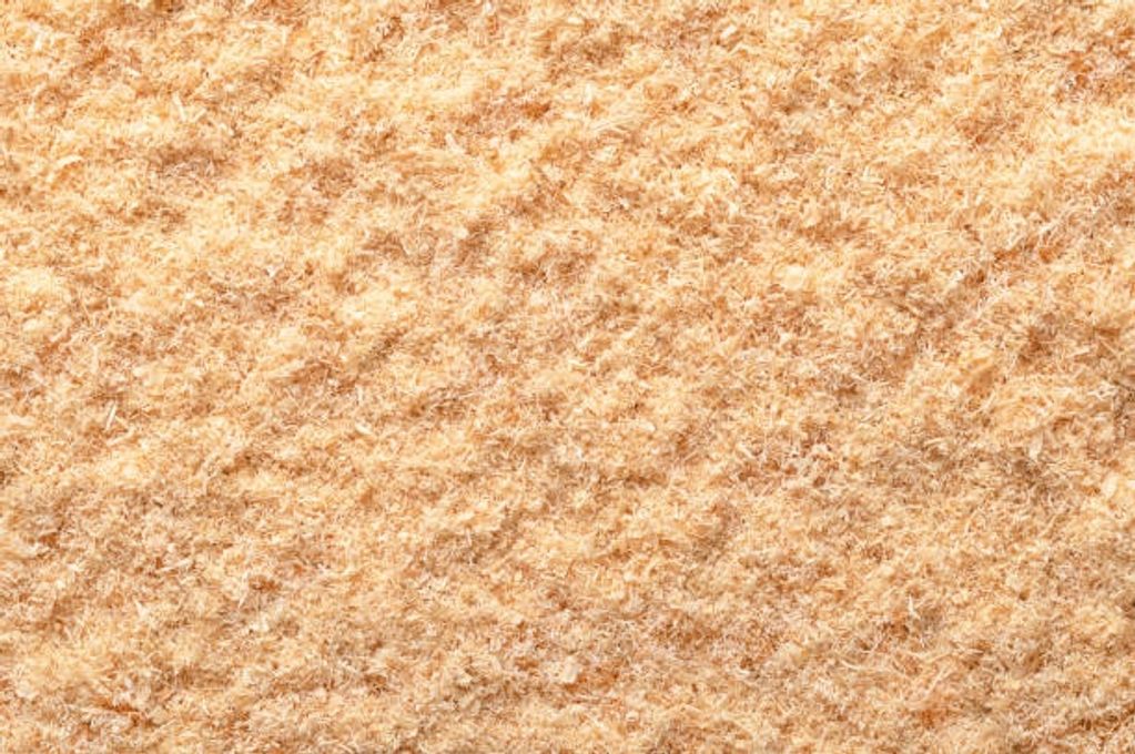 Close-up of fine wood shavings on a surface.