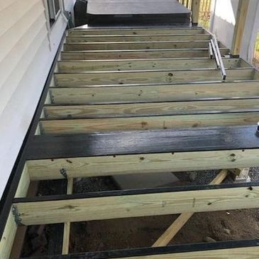 A frame of a deck with flashing tape attached