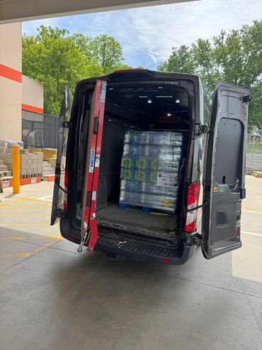 Open van loaded with pallet of bottled water ready for delivery.