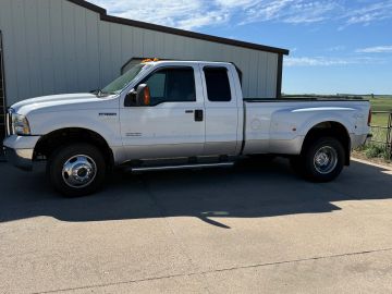 White Ford pickup truck parked beside a building on a sunny day.