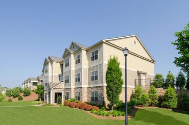 Three-story luxury apartment building exterior with landscaping at Greystone Summit Knoxville
