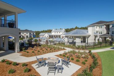 Apartment courtyard with seating area, fire pit, and landscaped walkways at Greystone at Auburn