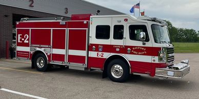 Red and white Bayport fire truck parked outside the fire station.