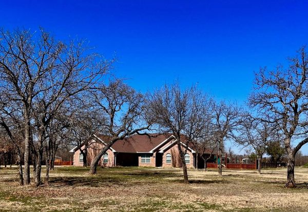 a brick house with trees in the winter