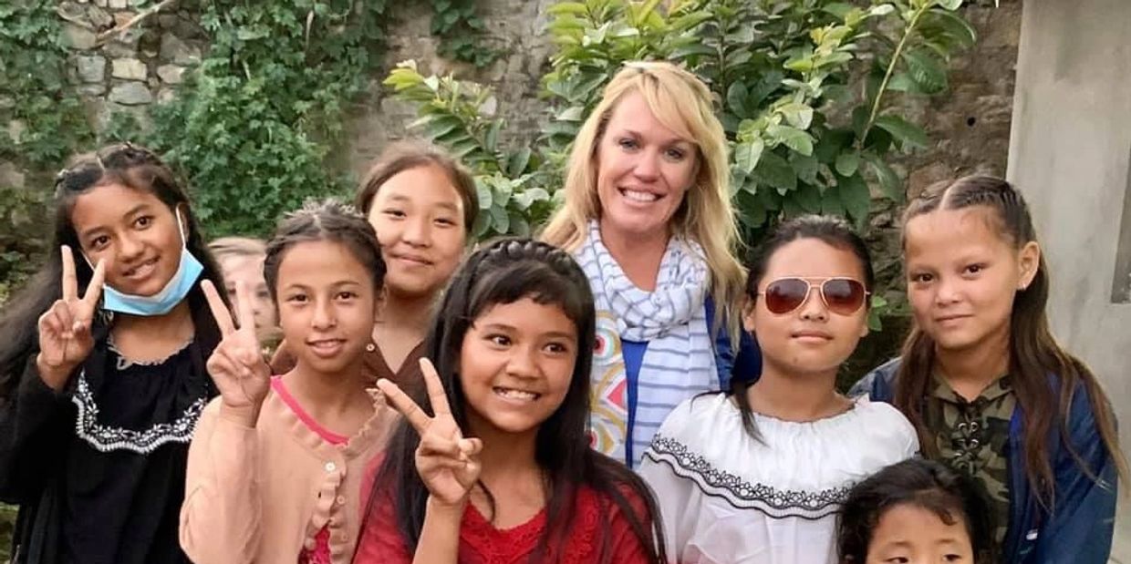 Linsey Ahart Taylor mission trip to Nepal posing for pic with orphanage school girls.