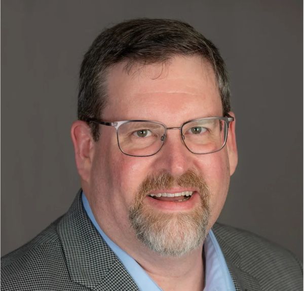 Smiling middle-aged man with glasses and a beard.
