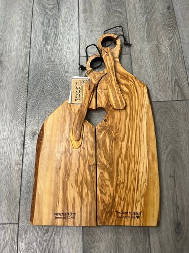 Two wooden cutting boards with heart cutout and personalized inscriptions.