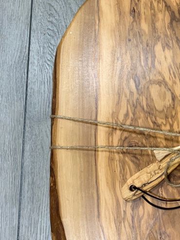 Wooden cutting board with a spatula tied with string and 'bon appetit' inscription.