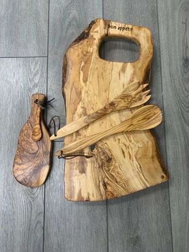 Rustic wooden kitchen utensils and cutting boards on a wooden floor.