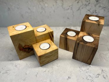 Wooden candle holders with tea light candles in natural and dark wood finishes.