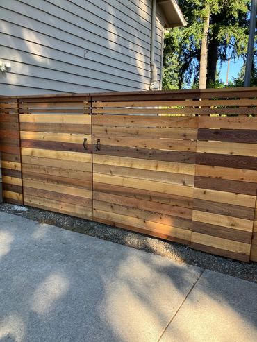 Horizontal double driveway gate with narrow boards on top. 
