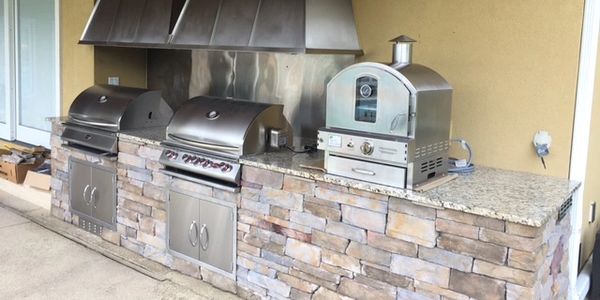 Outdoor kitchen with grill and pizza oven
