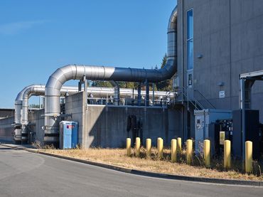 Exterior architecture photo of water treatment plant building and pipes.