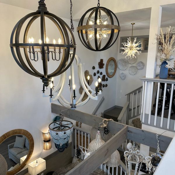 Elegant chandeliers and modern decor brighten a stylish living space with white walls and wooden accents.