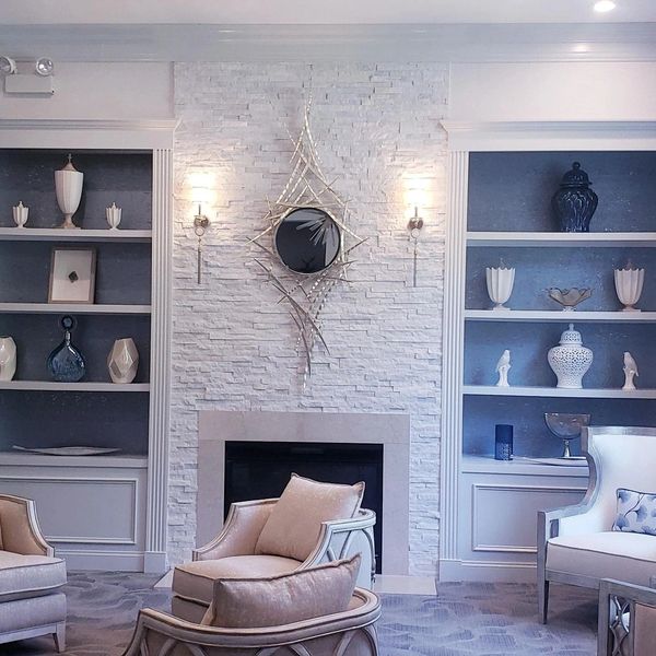 Elegant living room with a white stone fireplace and stylish decor.