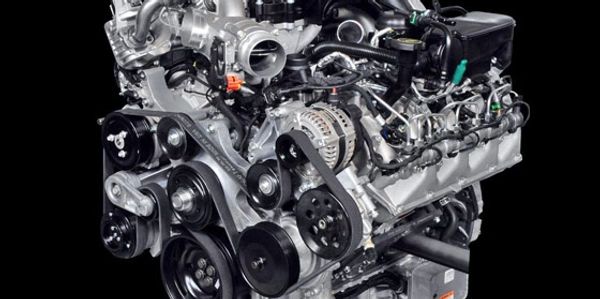 Close-up of a modern car engine with belts and pulleys.