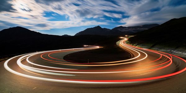 Light trails on a winding mountain road at night.