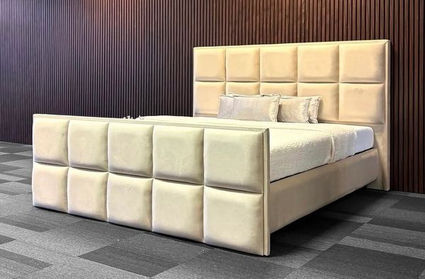 Modern beige upholstered bed with padded headboard and footboard.