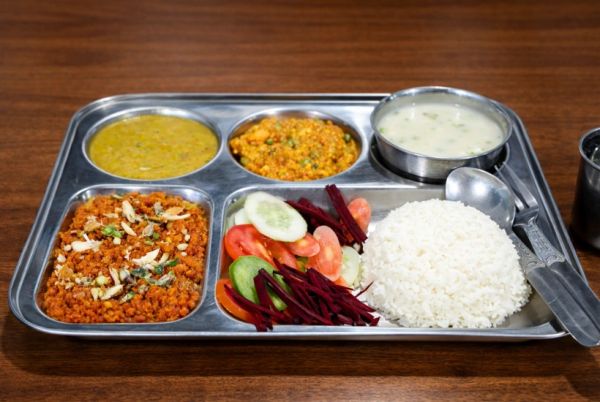 Indian thali with rice, vegetables, and lentils.