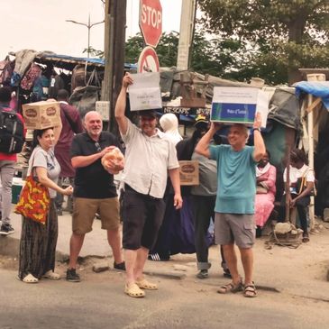 De nombreuses personnes marchent dans les rues en portant des aliments sur la tête.