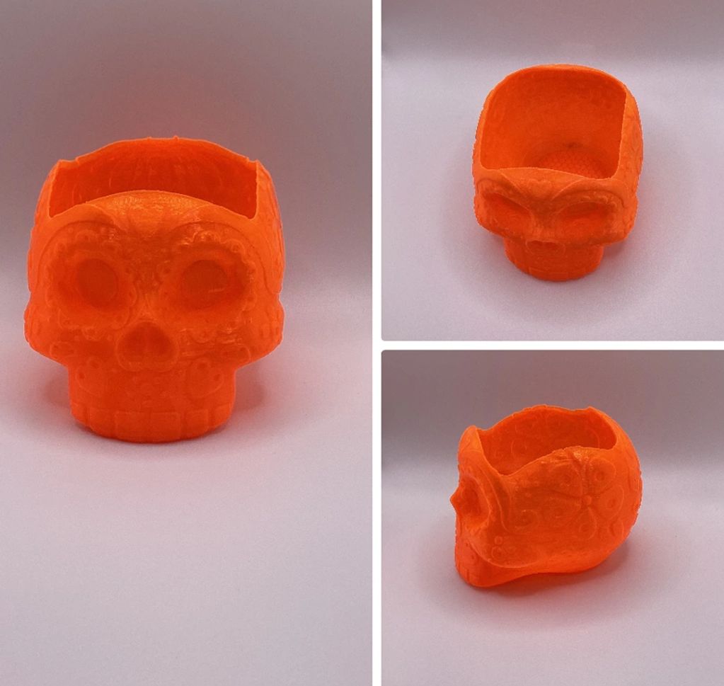 Orange skull-shaped decorative container with ornate designs.