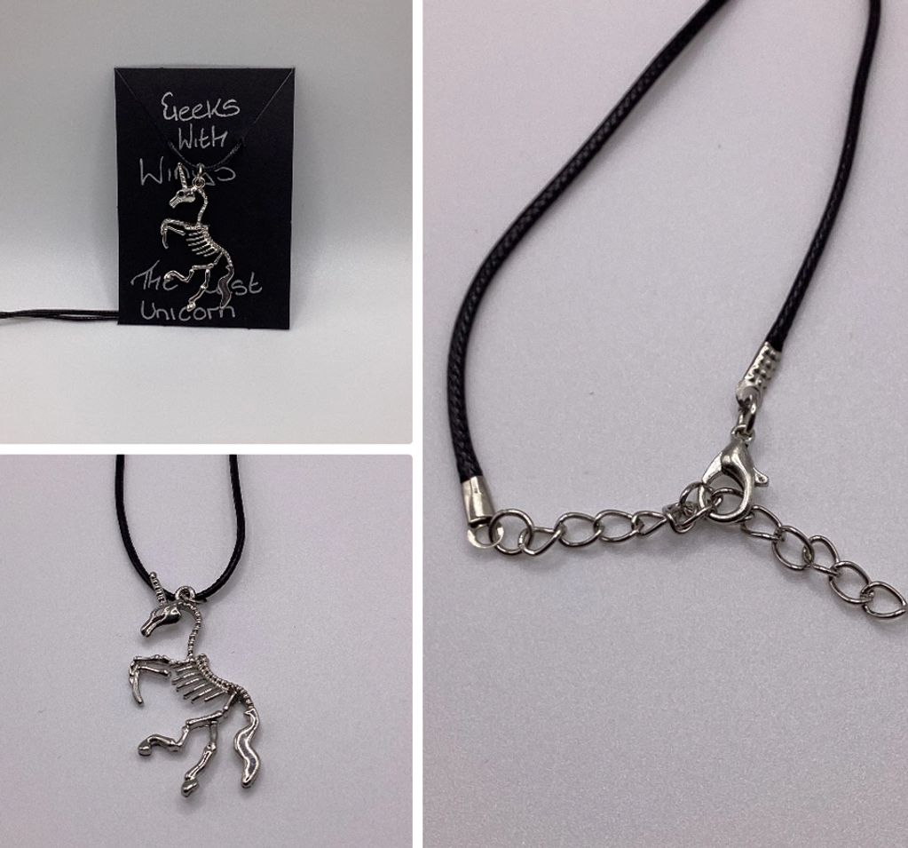 Skeleton unicorn necklace on a black cord.