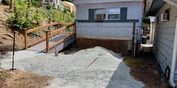 Gravel driveway next to a ramp and house.