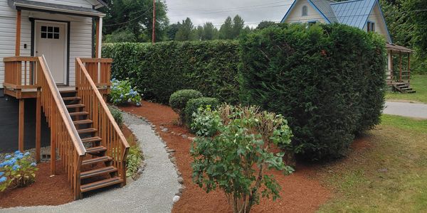 Wooden stairs leading to a house with a landscaped garden path.
