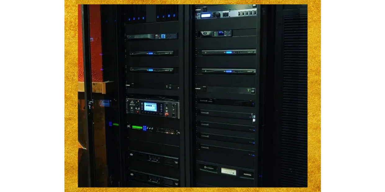 Server rack with multiple electronic devices and blue indicator lights.