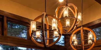Large wood and iron pendant lighting for mountain home design done by The Design Gallery