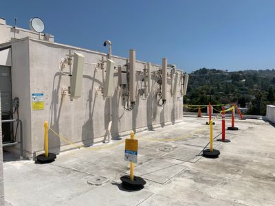 RF safety barricades surrounding rooftop antennas for worker protection