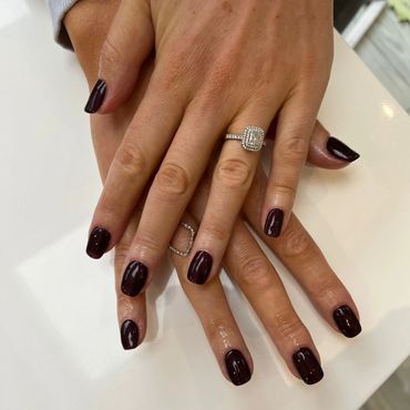 pair of hands showing manicure and engagement ring